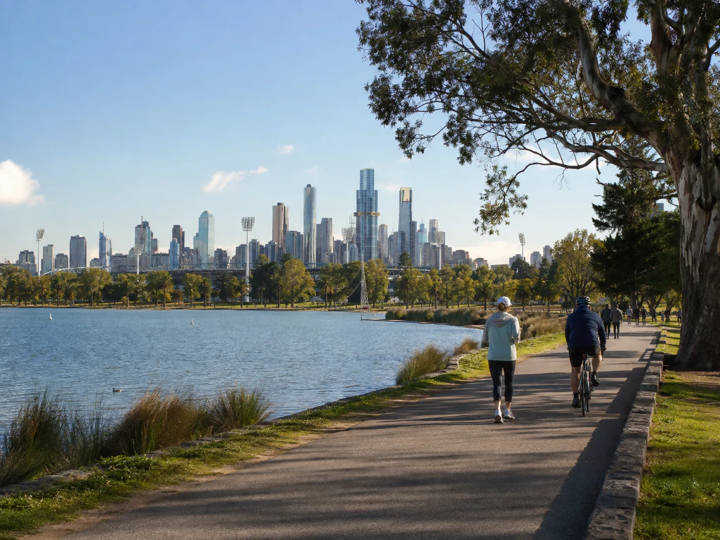 People walking and cycling beside Albert Park Lake near South Melbourne